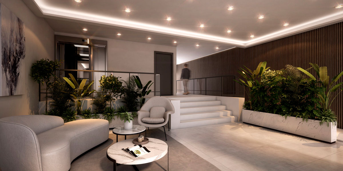 Lobby de Horus Art III, con estar, vegetación y acceso a ascensores